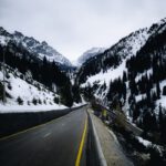 Captivating view of a road winding through snowy mountains in Almaty, Kazakhstan.