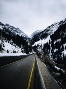 Captivating view of a road winding through snowy mountains in Almaty, Kazakhstan.
