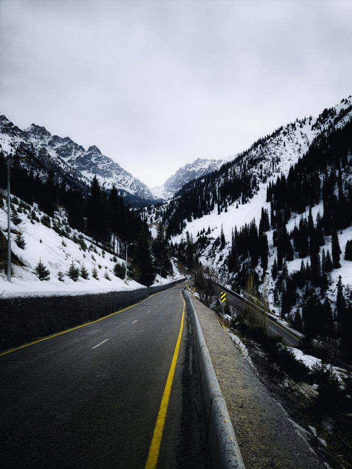 Captivating view of a road winding through snowy mountains in Almaty, Kazakhstan.